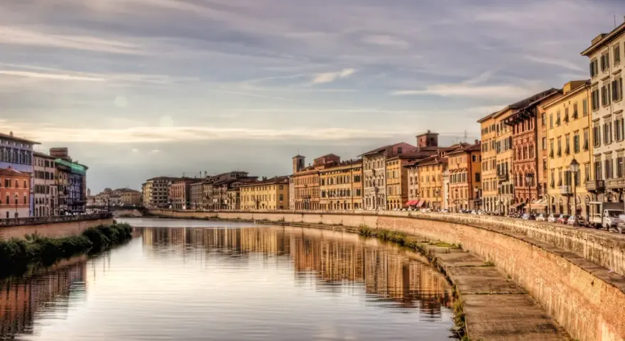 Lungarno a Pisa, con palazzi colorati che si specchiano nel fiume. Un'atmosfera da fiaba, tra Lucca e Pisa.