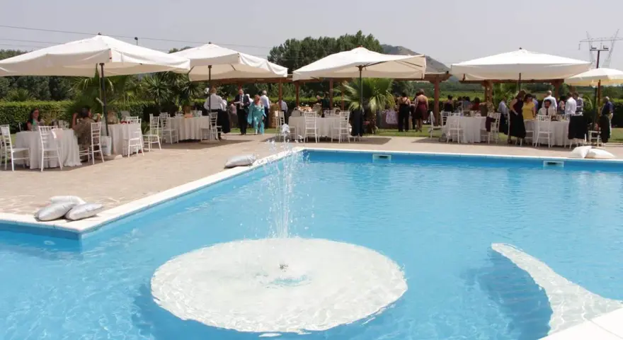 Un evento speciale alla Masseria Cardillo di Presenzano, con tavoli apparecchiati e ospiti vicino alla piscina con fontana.