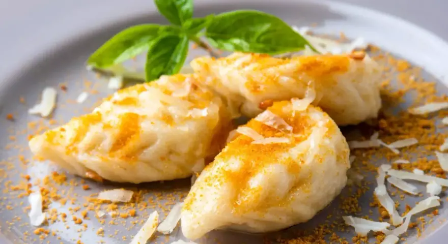 Malloreddus, un saporito cibo tipico sardo, conditi con formaggio grattugiato e una spolverata di zafferano.