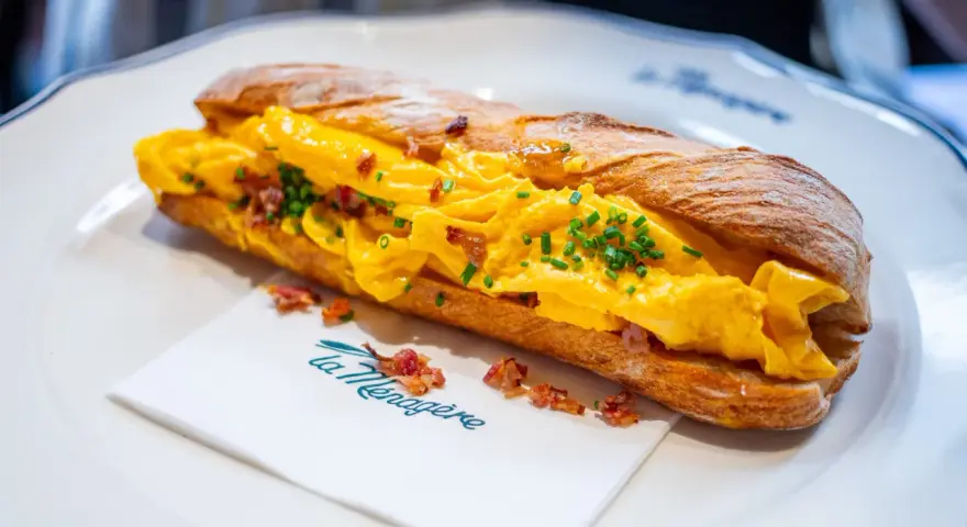 Panino con uova strapazzate, bacon croccante e erba cipollina. Un'ottima idea su cosa mangiare a Firenze per un pasto veloce e gustoso.