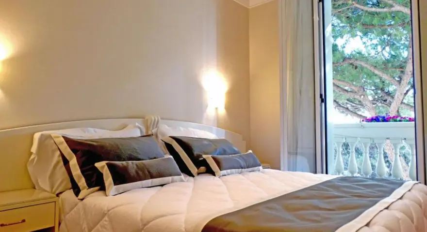 Camera accogliente con letto comodo e balcone fiorito. Ideale per chi cerca hotel Novecento Riccione recensioni positive.
