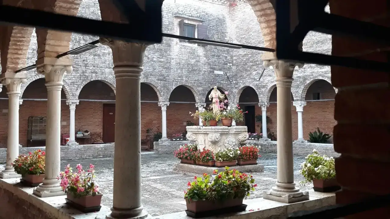Cortile con fontana e statua, circondato da arcate e colonne. Un angolo di pace, un vero combo Venezia.