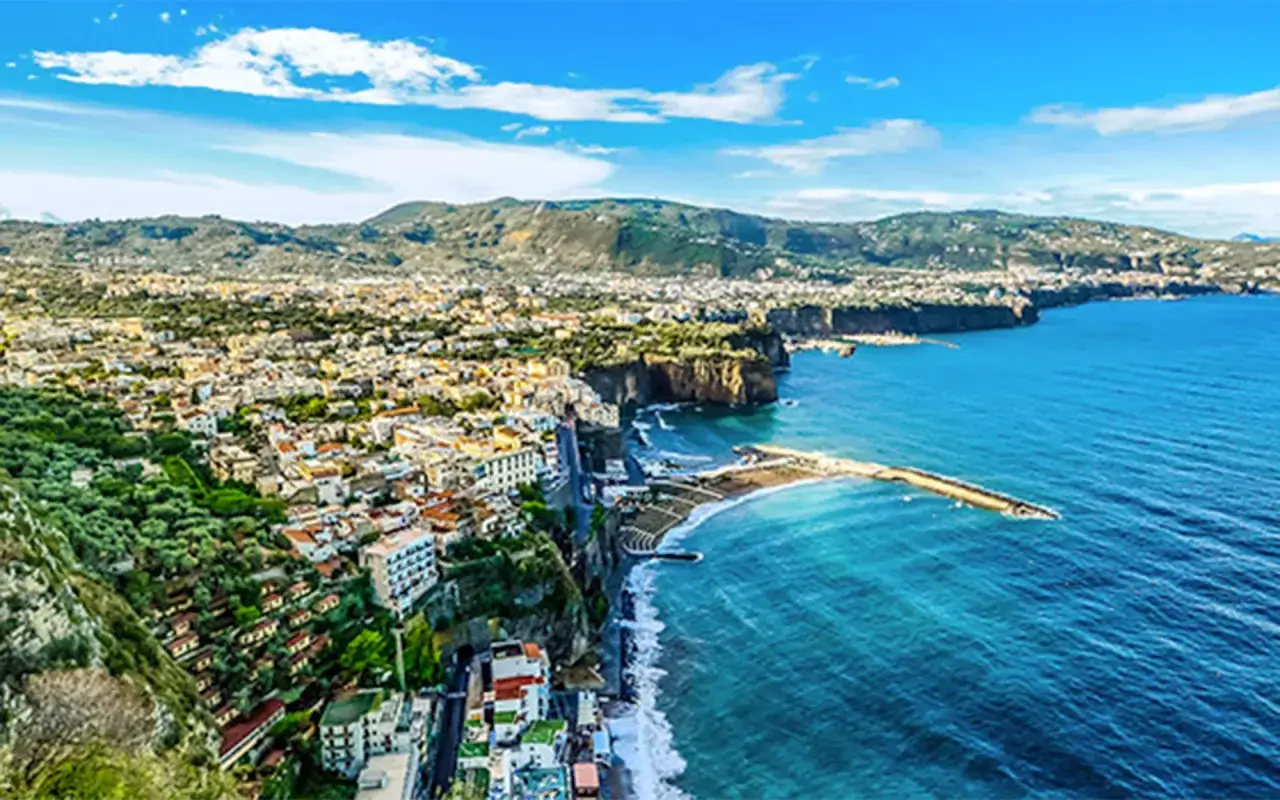 Vista panoramica di Sorrento, con case aggrappate alla scogliera e il mare blu. Perfetto per scoprire cosa vedere a Napoli in 3 giorni.