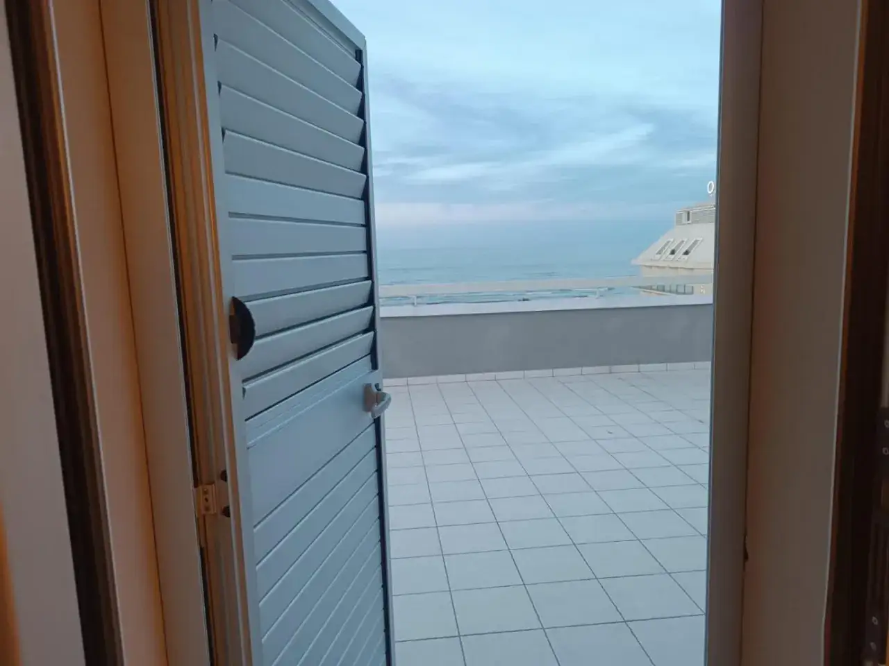 Vista mare da una terrazza con persiana aperta. Un'ottima location per le tue vacanze, come suggeriscono le recensioni dell'hotel Le Terrazze Riccione.
