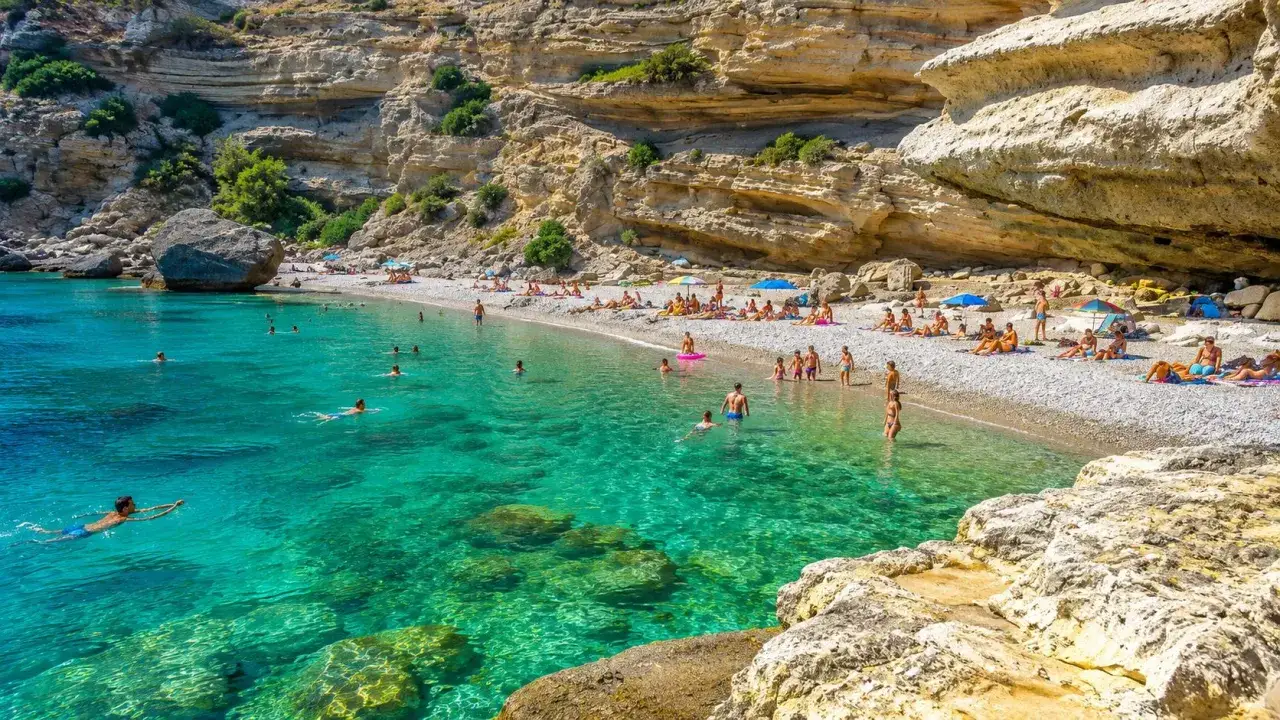 Acque cristalline e scogliere imponenti caratterizzano le spiagge di Ventotene, dove bagnanti si godono il sole e il mare turchese.