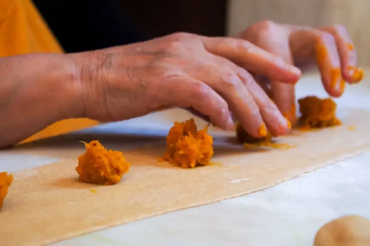 Mani che preparano ravioli di zucca, un classico tra i piatti tipici pavesi.