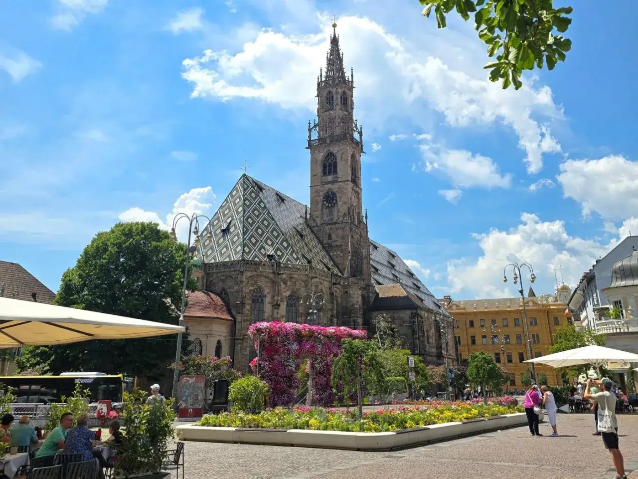 Piazza Duomo a Bolzano, con la cattedrale e aiuole fiorite. Perfetto per scoprire cosa vedere a Bolzano in un giorno.