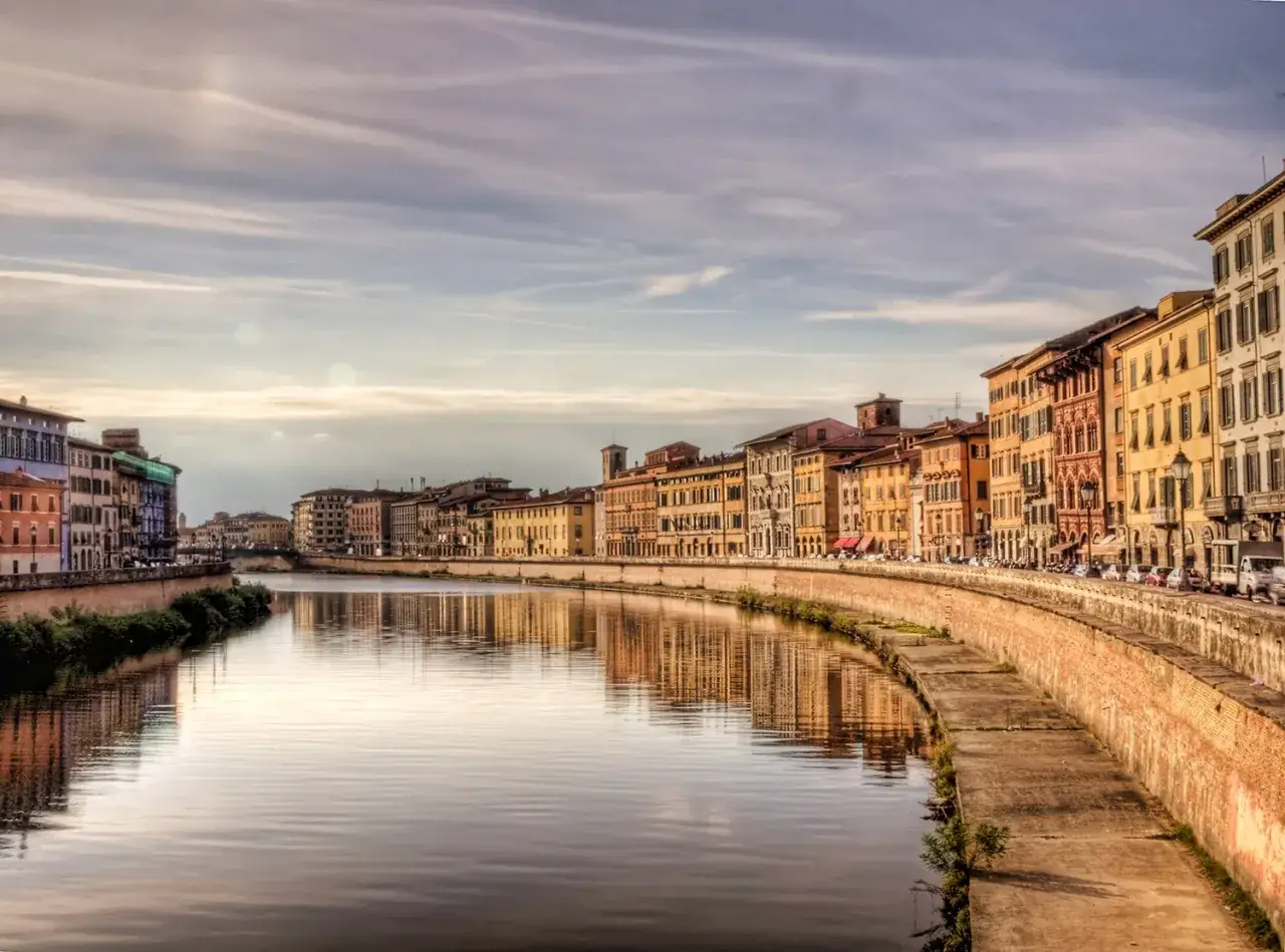 Lungarno a Pisa, con palazzi colorati che si specchiano sull'Arno. Un'atmosfera da sogno, tra Lucca e Pisa.