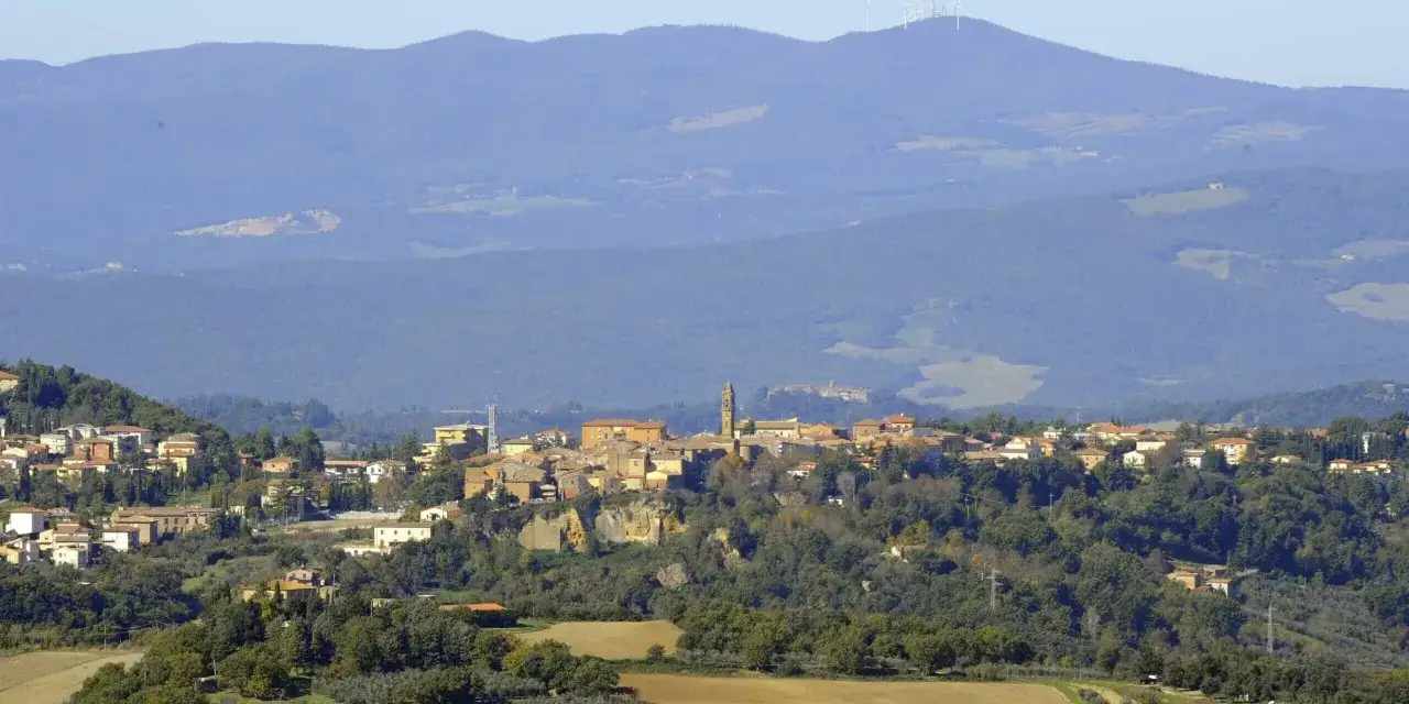 Panoramica di Pomarance, con il borgo arroccato su una collina e le montagne sullo sfondo. Scopri cosa vedere in questo incantevole paese.