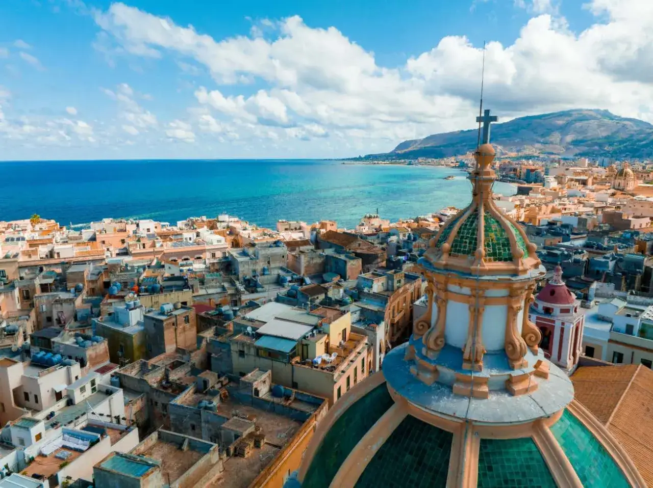 Vista aerea di Trapani con cupola verde e mare blu. Perfetto per scoprire cosa vedere a Trapani in un giorno.