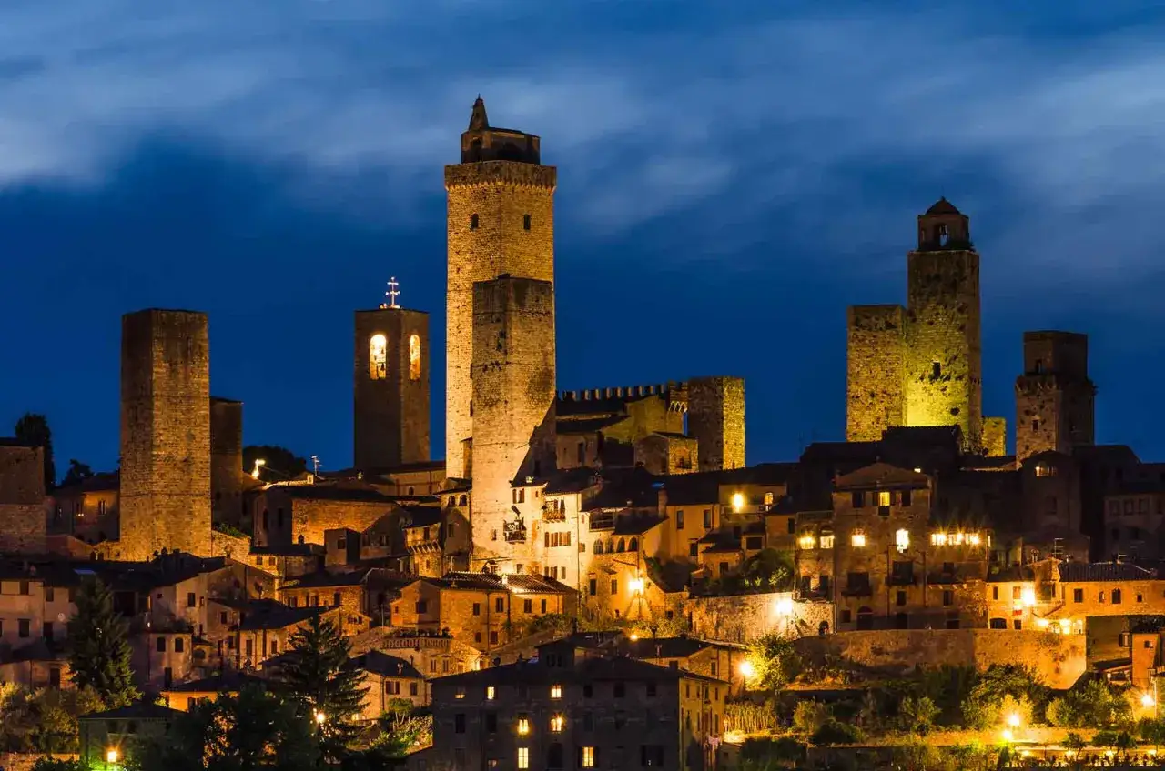 Torri medievali illuminate di notte a San Gimignano, un'emozione da vivere in un giorno, magari dopo aver visitato Volterra.