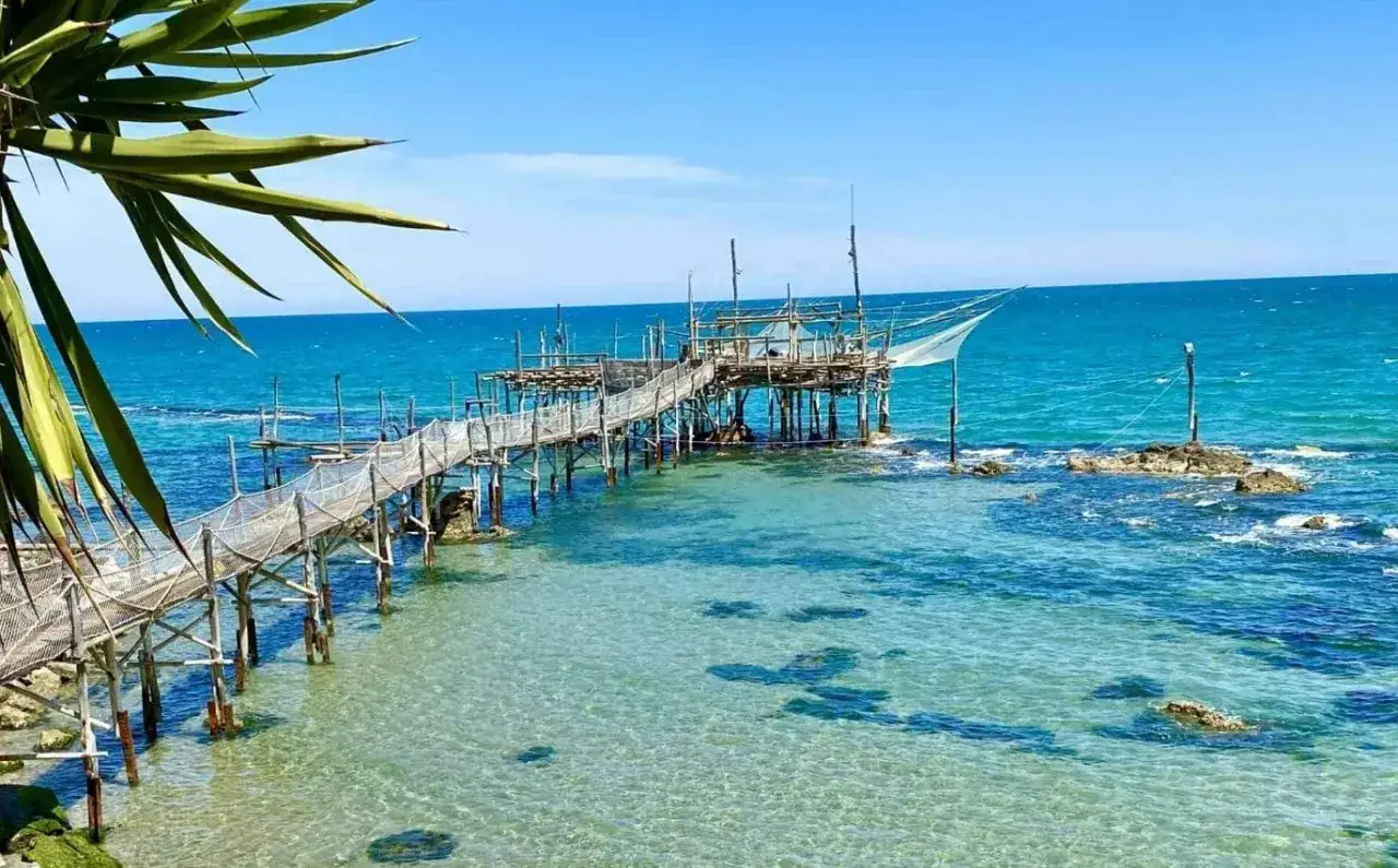 Trabocchi sull'Adriatico, un'immagine iconica delle spiagge Abruzzo. Strutture di legno su palafitte con reti da pesca, acque cristalline e cielo azzurro.
