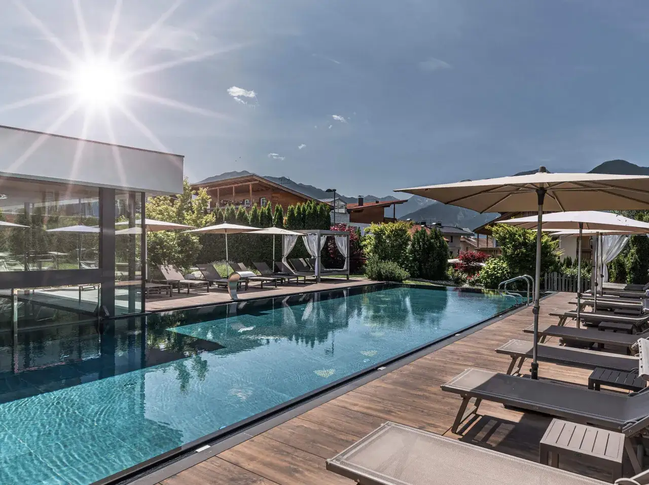 Piscina all'aperto con lettini e ombrelloni, sotto il sole splendente. Un'oasi di relax al hotel sun naz.