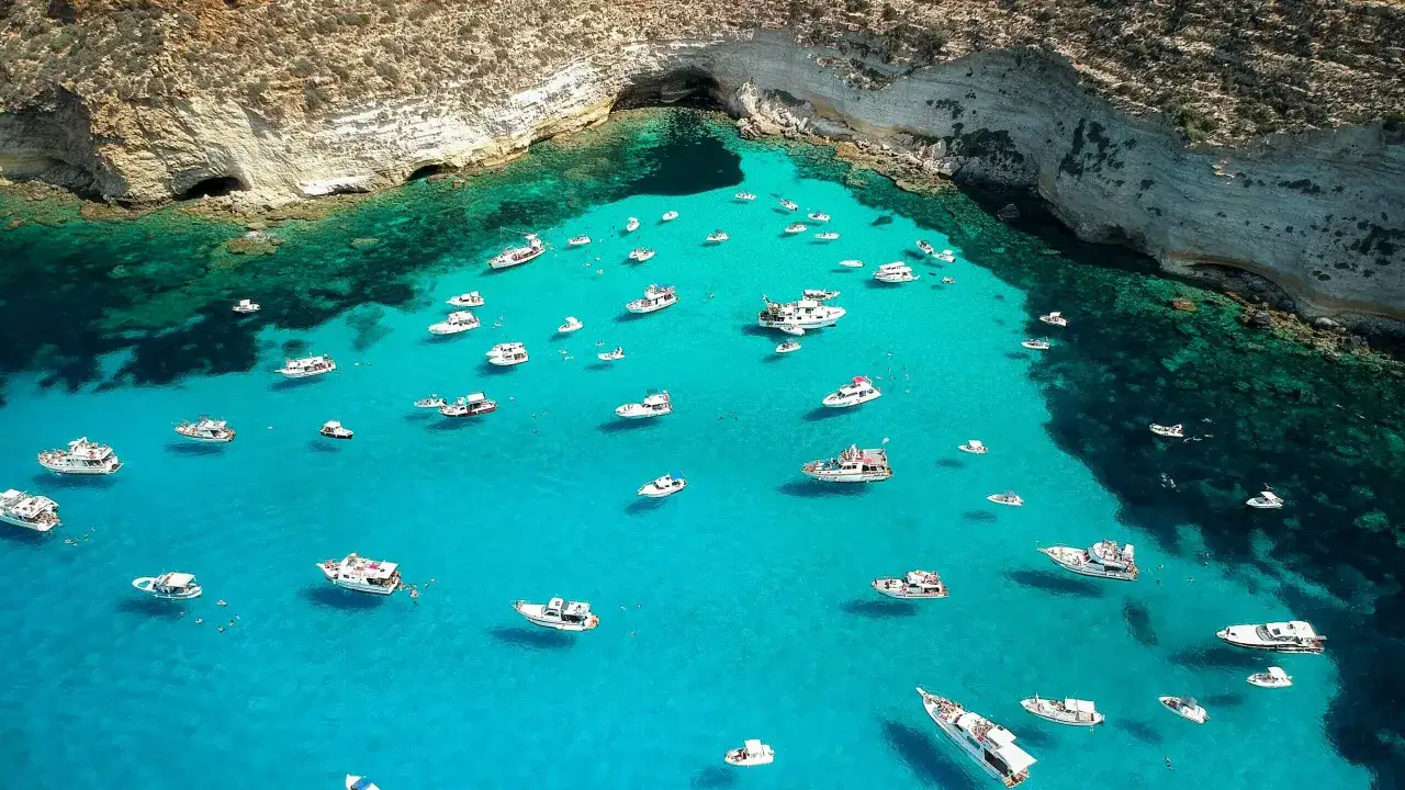 Grotte e acque cristalline, un paradiso di barche e nuotatori. Le migliori spiagge di Lampedusa, un sogno azzurro.