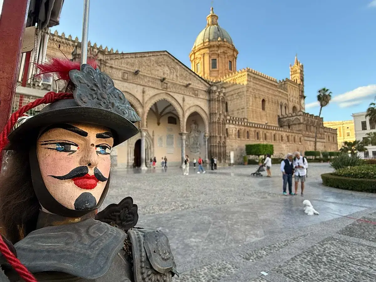 Un pupo siciliano saluta il Duomo di Palermo, un'icona per il tuo itinerario.