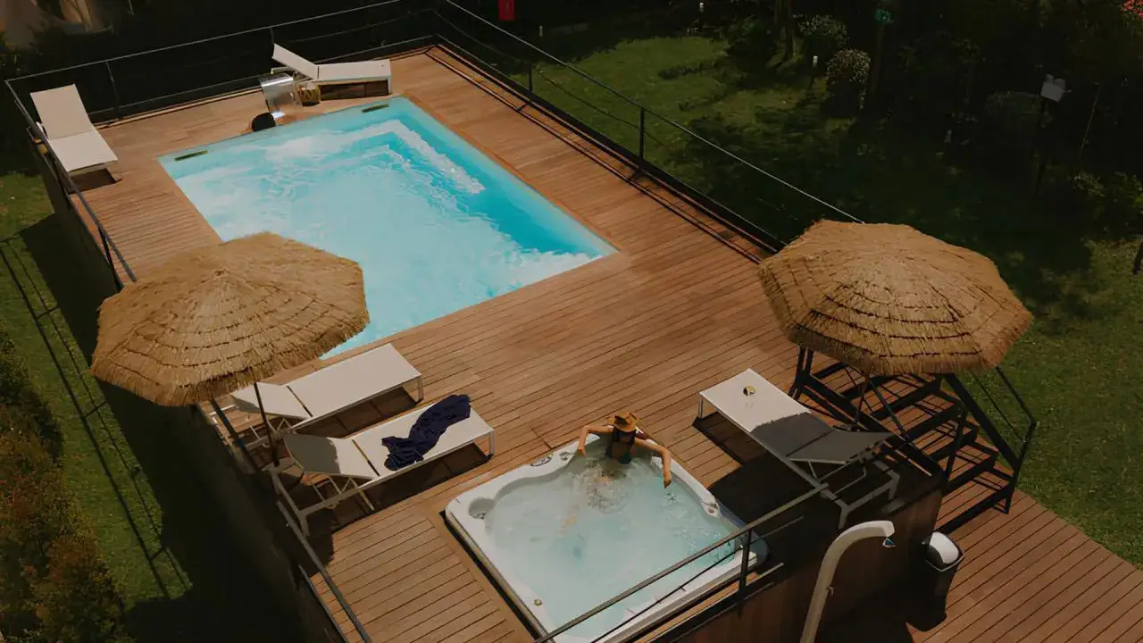 Relax in the jacuzzi at the Relais Corte degli Aragonesi, with a pool and sun loungers nearby.