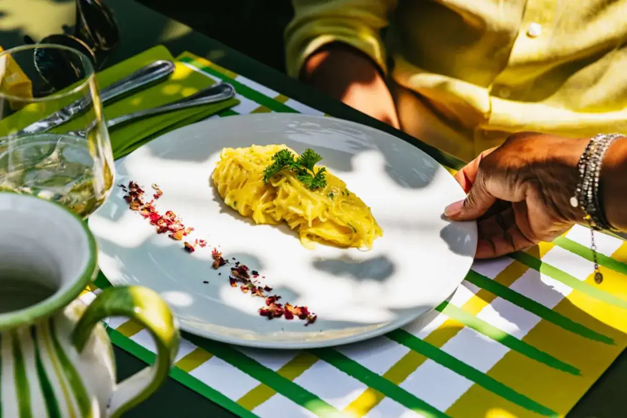 Un piatto di spaghetti al limone, uno dei piatti tipici di Sorrento, servito su un tavolo all'aperto.