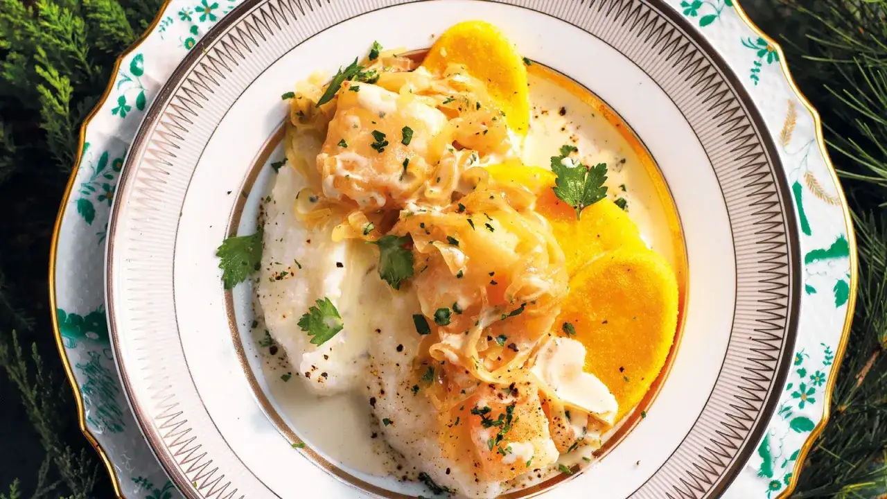 Baccalà mantecato con polenta, un classico delle ricette tipiche del Veneto, servito su un elegante piatto decorato.