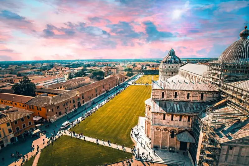 Un suggestivo itinerario Toscana 5 giorni inizia con la Piazza dei Miracoli a Pisa, con la sua cattedrale e il battistero sotto un cielo rosa.